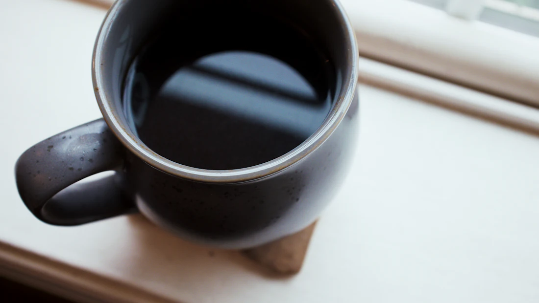 A quiet cup of coffee on a windowsill in morning light